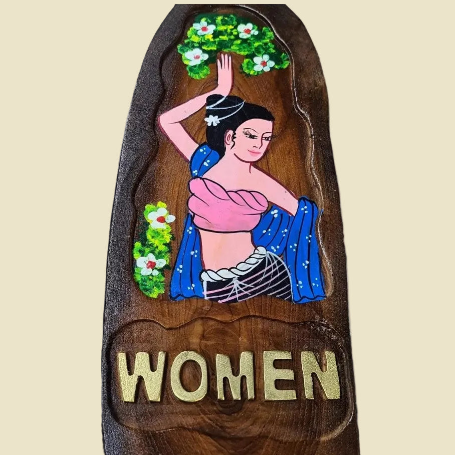 A pair of hand-carved teak wood restroom signs featuring traditional Thai man and woman figures.