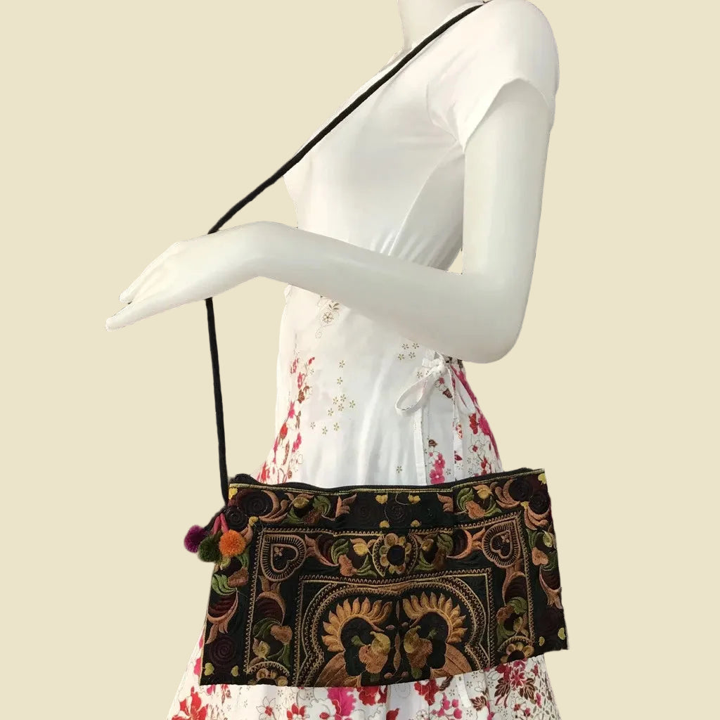 Handmade Hmong embroidered crossbody bag with colorful pom-poms and tribal patterns, authentic Thai bohemian shoulder purse.