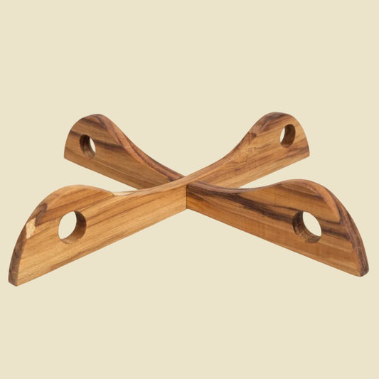 Collapsible Teak Wood cross-shaped trivet on a natural wood background