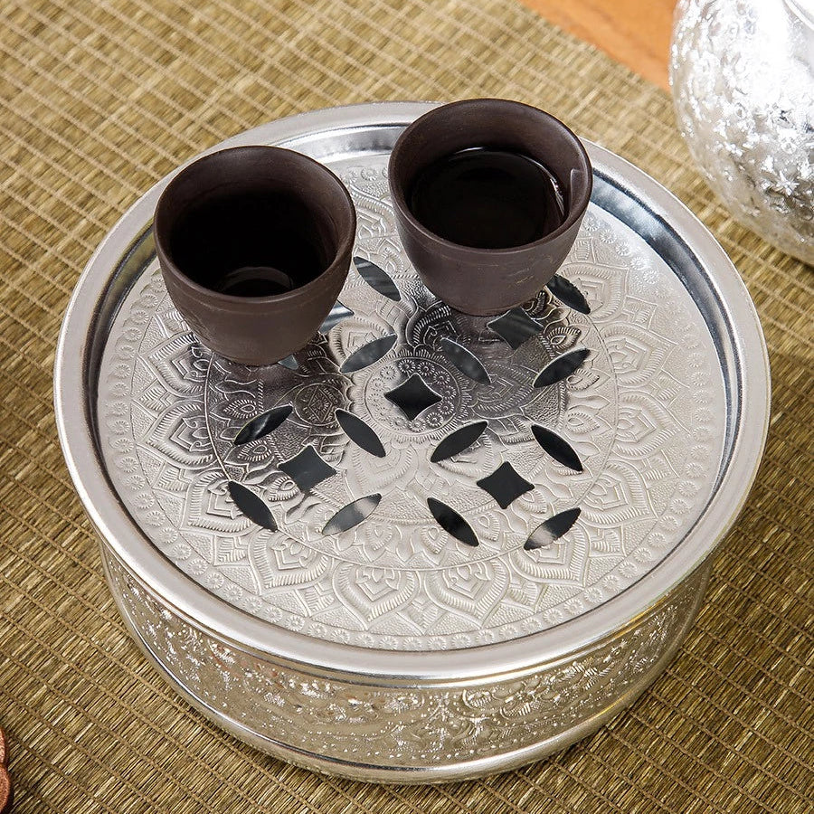 Close-up of the rich, hand-pressed traditional Thai chisel pattern on a silver tin alloy teapot base.