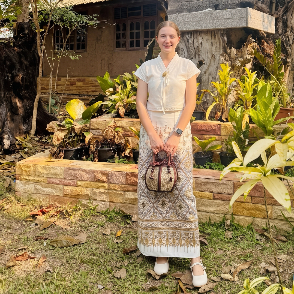 Woman carrying a 6-inch pumpkin-shaped straw woven bag on her wrist.