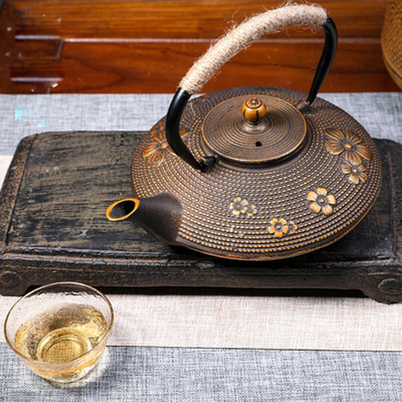 Premium 900ml floral cast iron kettle tea infuser featuring red blossoms and a rustic rope handle, perfect for tea lovers.