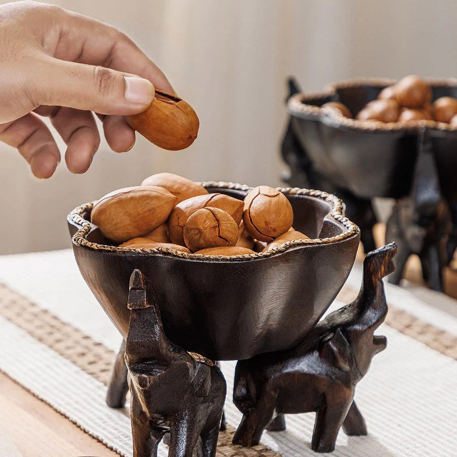 Hand-carved wooden elephant fruit tray with flower-shaped bowl and braided bamboo rim.