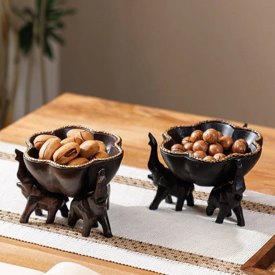 Hand-carved wooden elephant fruit tray with flower-shaped bowl and braided bamboo rim.