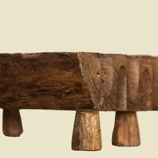 Hand-carved teak wood soap dish with raised legs for drainage, featuring natural wood grain and a rustic artisan design.