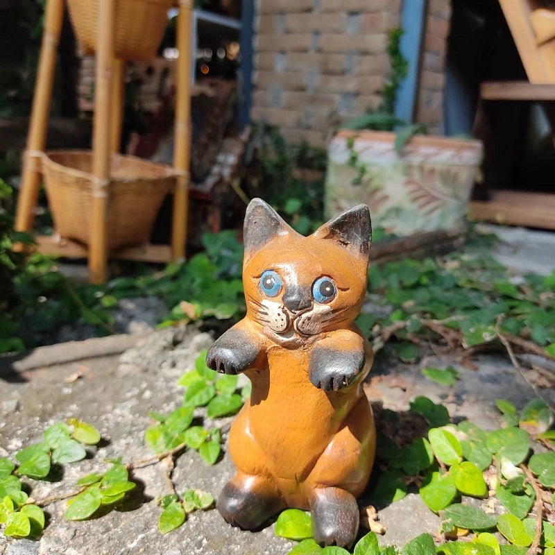 Handcrafted wooden cat figurine in a playful pose