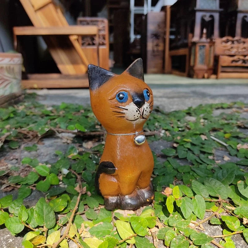 Handcrafted wooden cat figurine in a playful pose