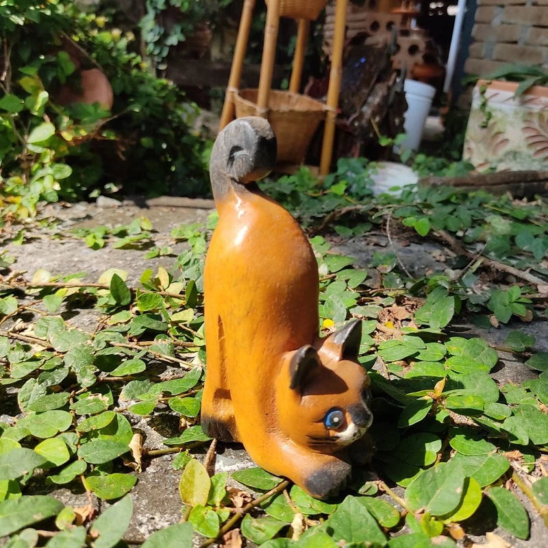 Handcrafted wooden cat figurine in a playful pose