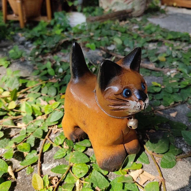 Handcrafted wooden cat figurine in a playful pose