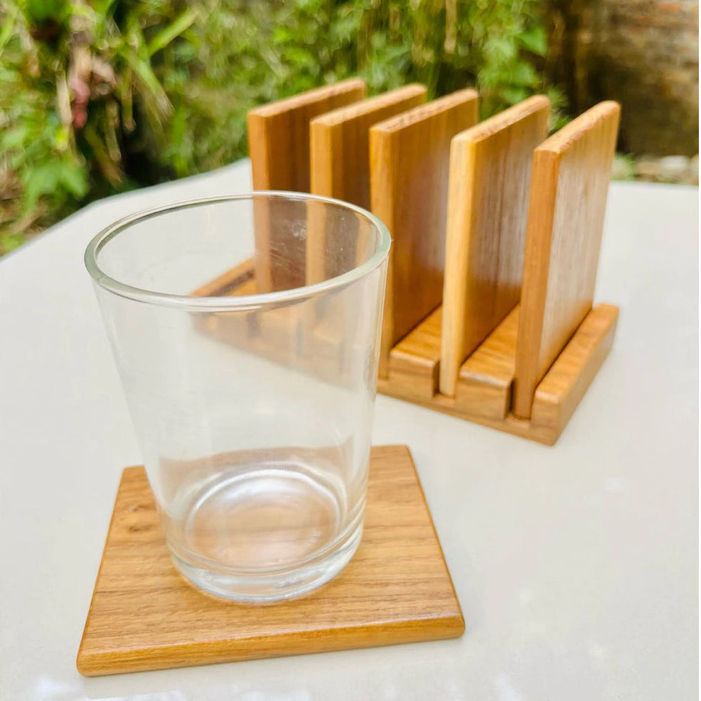 Handmade 7-piece golden teak wood coaster set with a vertical storage rack, featuring natural wood grain and water-resistant coating.