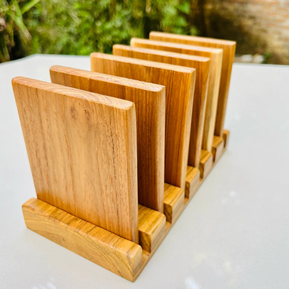 Handmade 7-piece golden teak wood coaster set with a vertical storage rack, featuring natural wood grain and water-resistant coating.