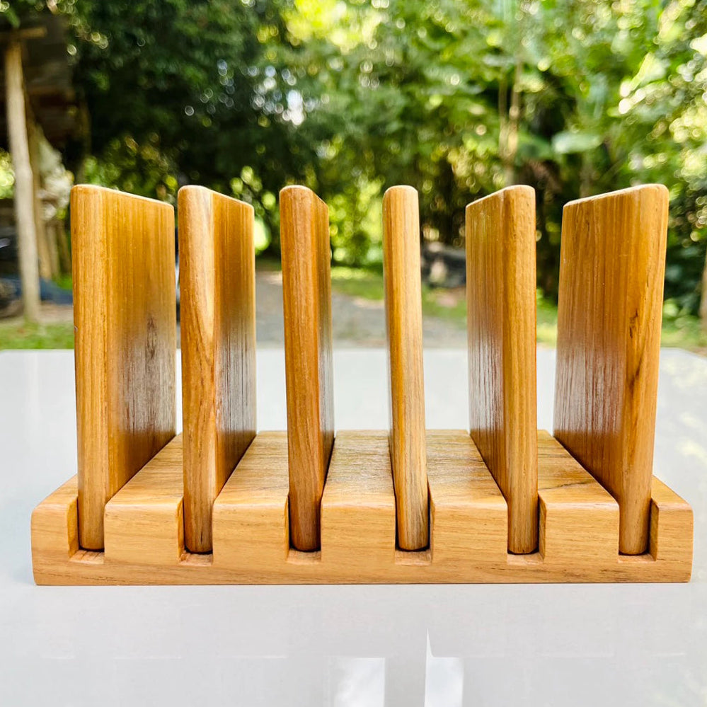 Handmade 7-piece golden teak wood coaster set with a vertical storage rack, featuring natural wood grain and water-resistant coating.