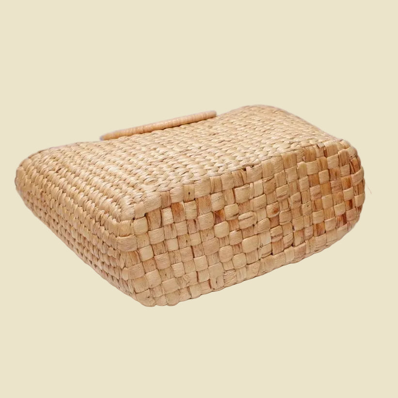 Handmade woven water hyacinth tote bag with circular rattan handles and fabric lining, eco-friendly straw bag for summer fashion.