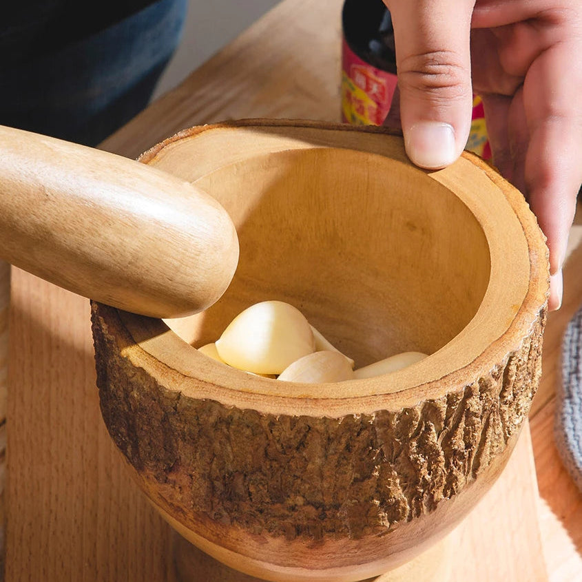 Close-up of a thick-walled wooden mortar bowl showing the 2.5cm depth for easy garlic grinding.