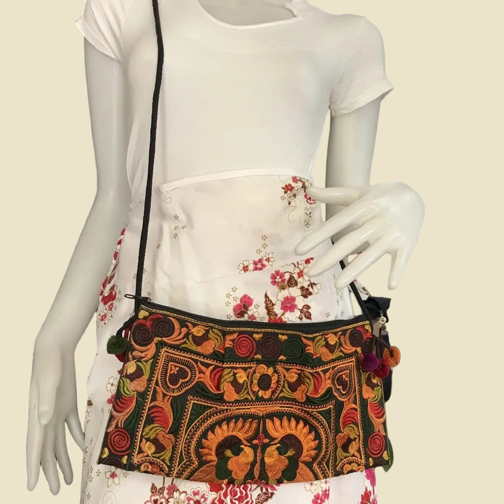 Handmade Hmong embroidered crossbody bag with colorful pom-poms and tribal patterns, authentic Thai bohemian shoulder purse.
