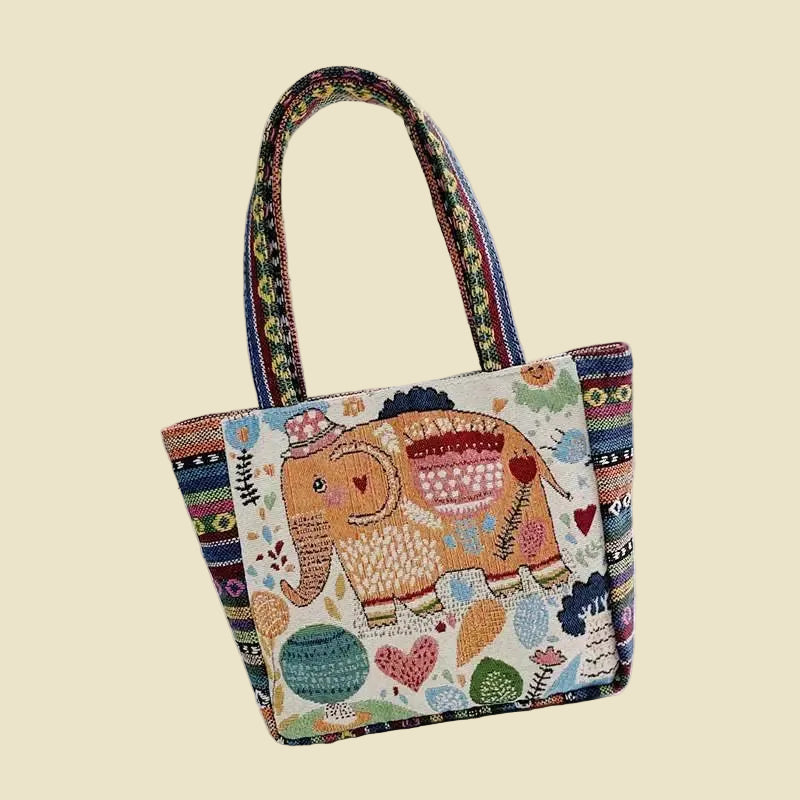 Woven canvas tote bag with colorful Thai elephant embroidery, featuring a zipper and boho-inspired design.
