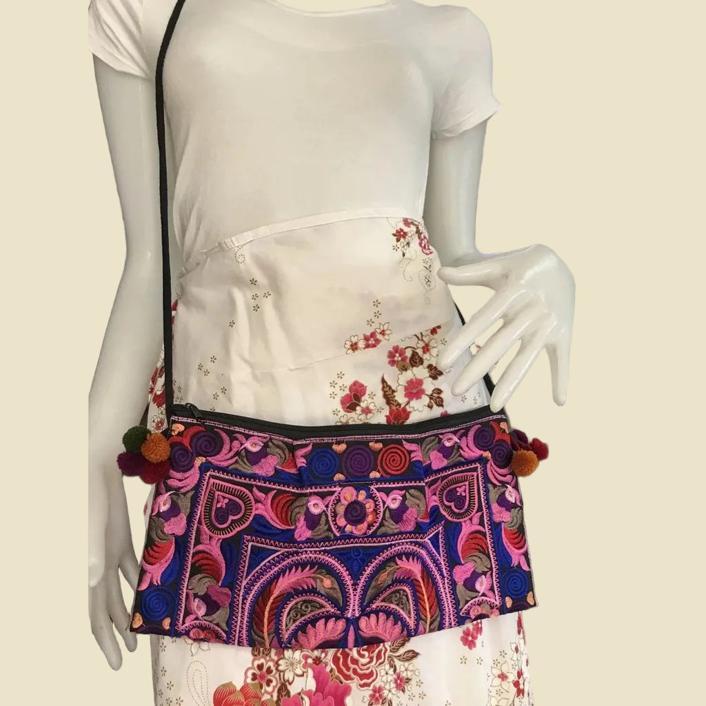 Handmade Hmong embroidered crossbody bag with colorful pom-poms and tribal patterns, authentic Thai bohemian shoulder purse.