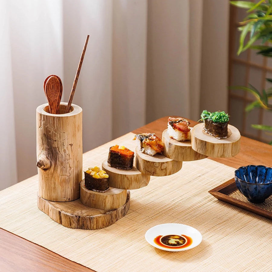 Person using chopsticks to pick up sushi from a food-safe unpainted wooden tiered serving tray.