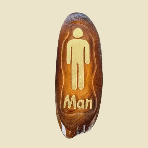 A pair of rustic teak wood restroom door signs with carved Man and Lady figures and natural wood grain.