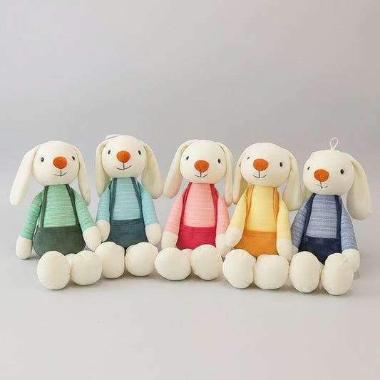 Soft long eared bunny plush toys in pastel suspenders on white shelf