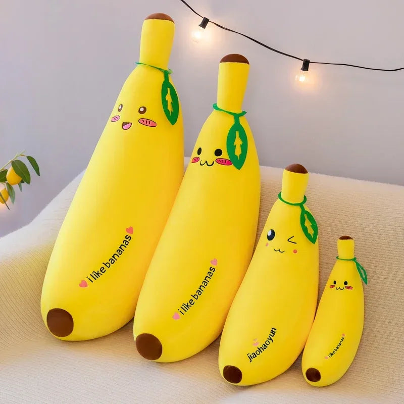 Three yellow giant banana plush body pillows in different sizes, featuring cute kawaii embroidered faces