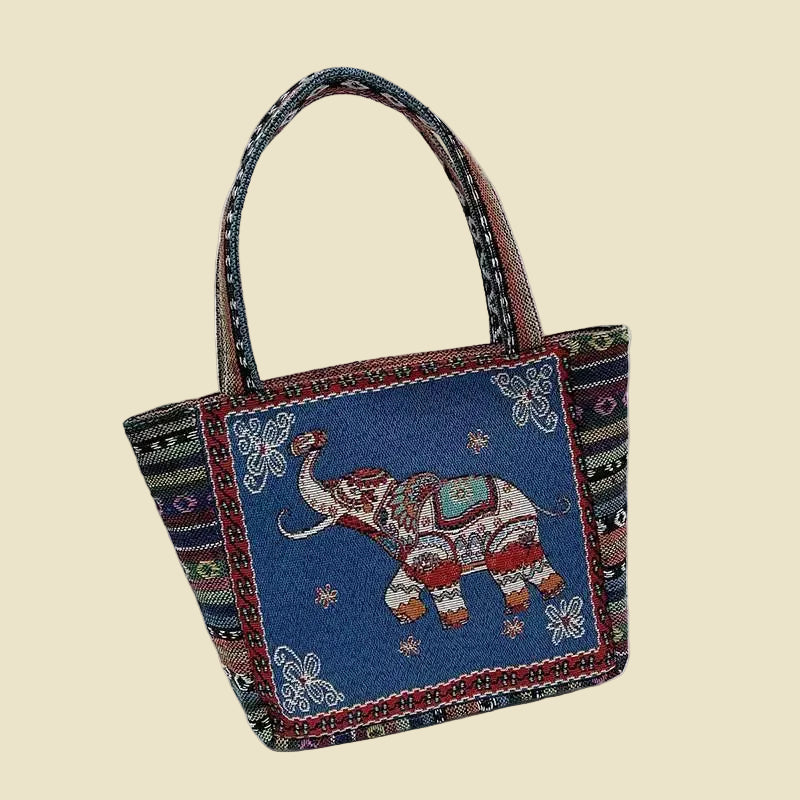 Woven canvas tote bag with colorful Thai elephant embroidery, featuring a zipper and boho-inspired design.
