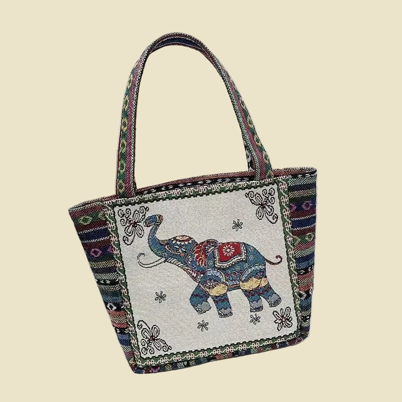 Woven canvas tote bag with colorful Thai elephant embroidery, featuring a zipper and boho-inspired design.