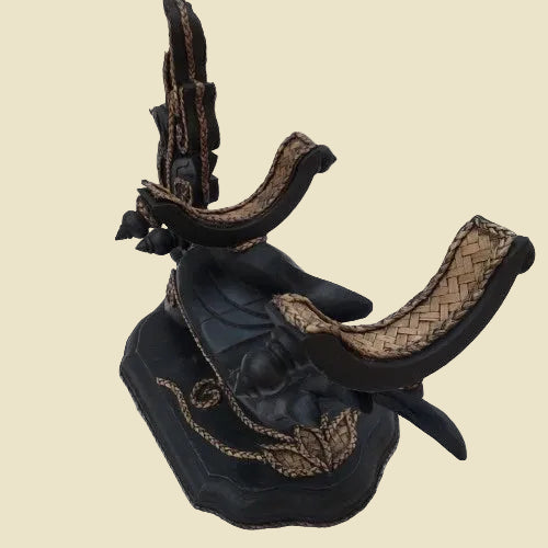 Unique handcrafted Thai Rain Tree wood wine bottle holder in a hand-shaped design with woven rattan accents, displayed on a tabletop.