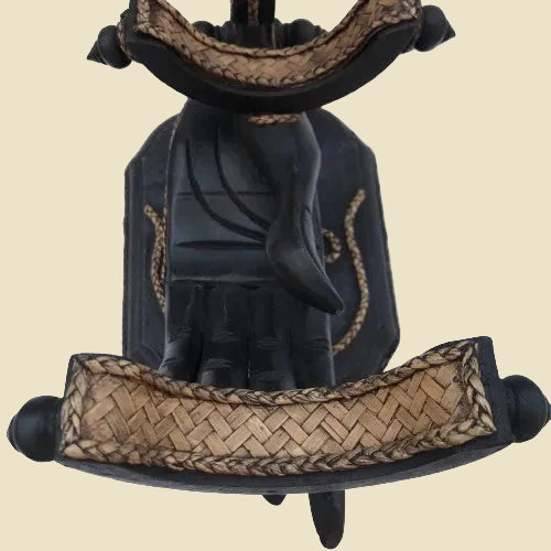 Unique handcrafted Thai Rain Tree wood wine bottle holder in a hand-shaped design with woven rattan accents, displayed on a tabletop.