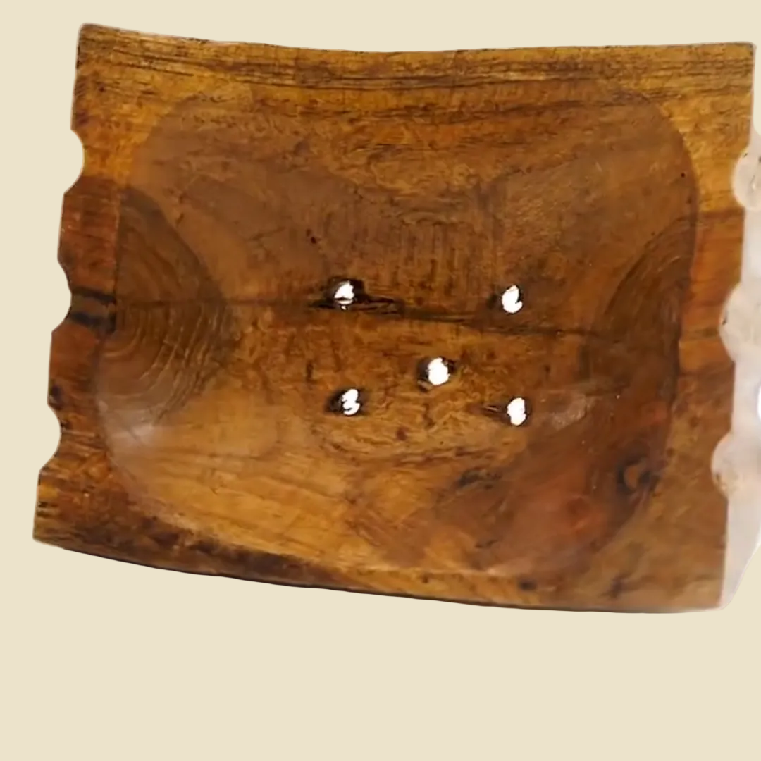 Hand-carved teak wood soap dish with raised legs for drainage, featuring natural wood grain and a rustic artisan design.
