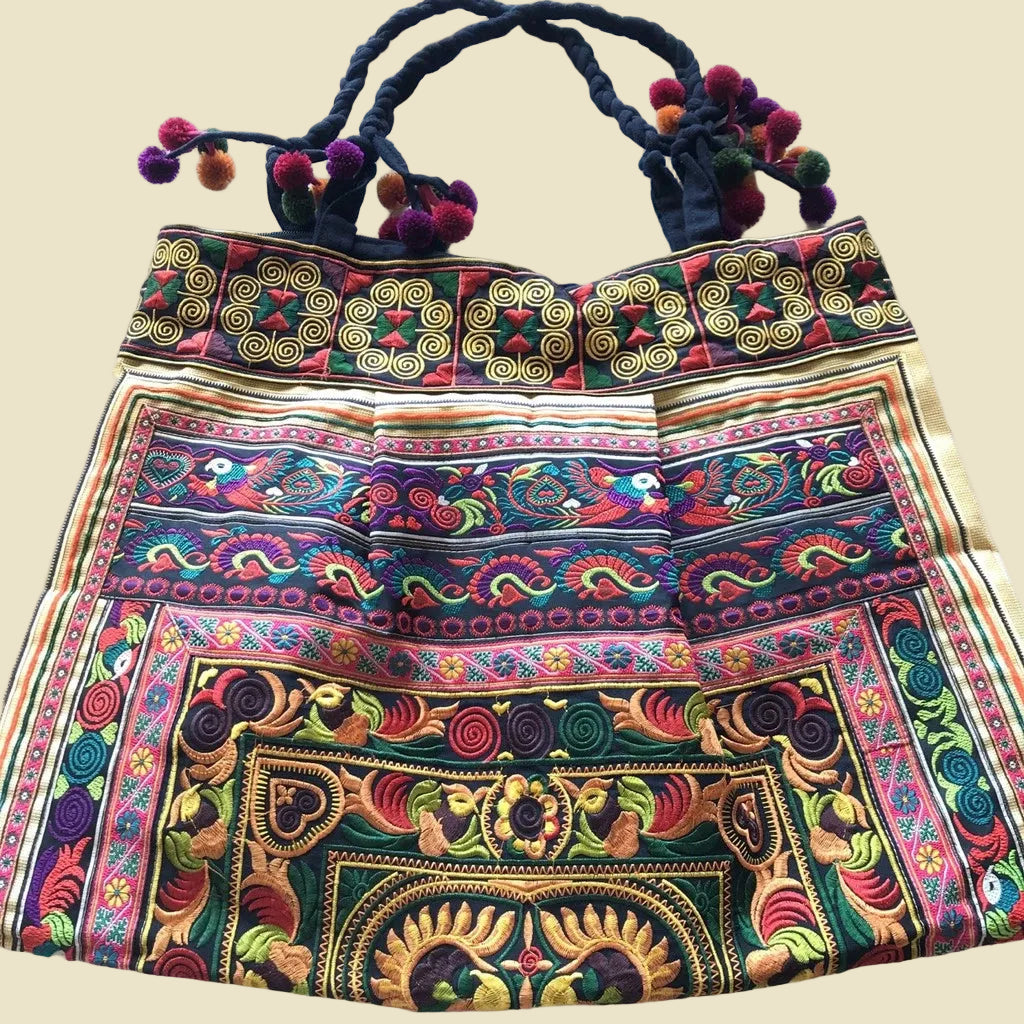 Vibrant handcrafted Thai Hmong tribal embroidered shoulder bag with colorful pom-poms and zipper closure, authentic bohemian style.