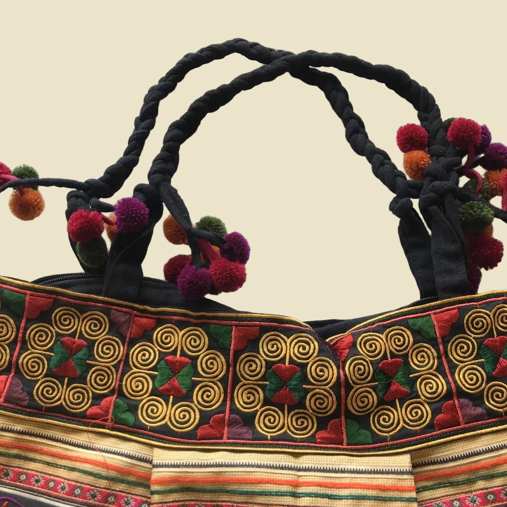 Vibrant handcrafted Thai Hmong tribal embroidered shoulder bag with colorful pom-poms and zipper closure, authentic bohemian style.