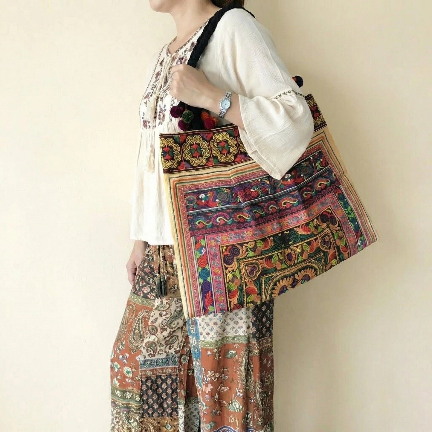 Vibrant handcrafted Thai Hmong tribal embroidered shoulder bag with colorful pom-poms and zipper closure, authentic bohemian style.