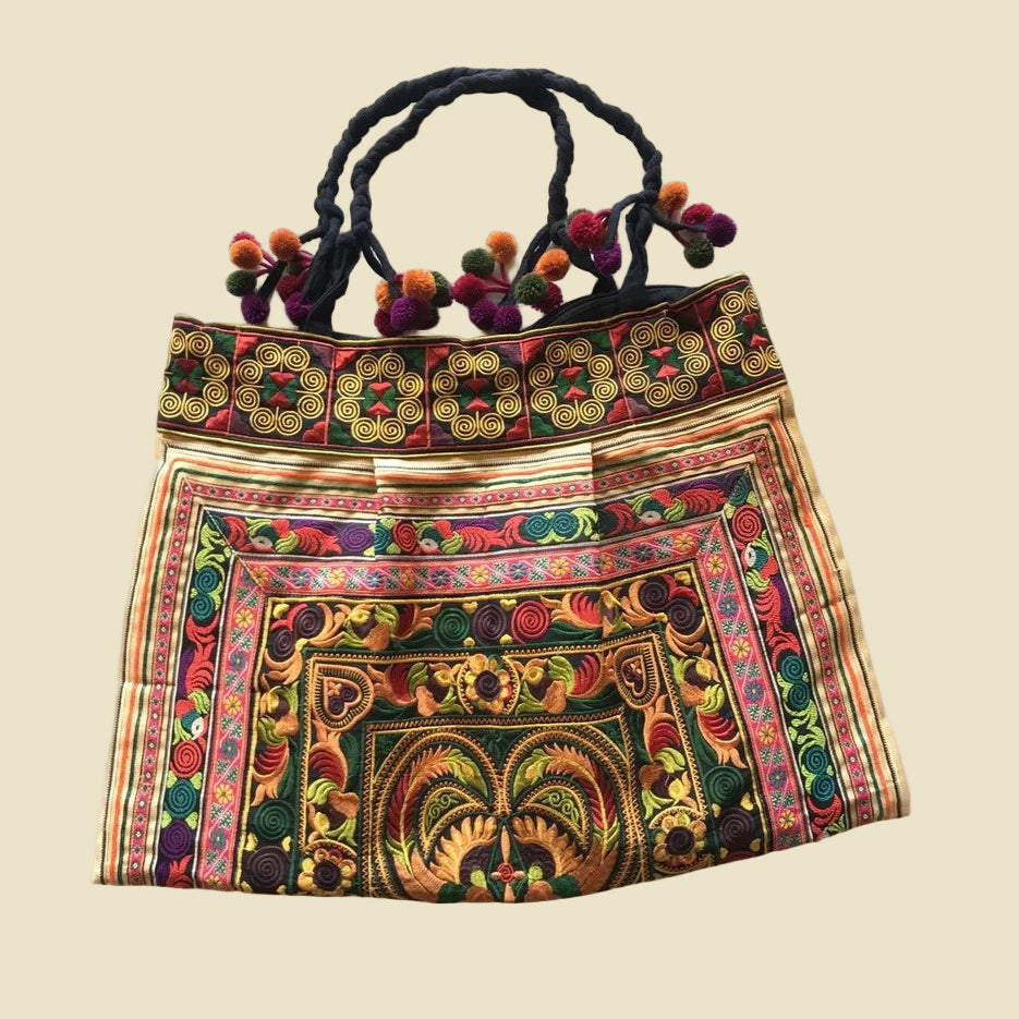 Vibrant handcrafted Thai Hmong tribal embroidered shoulder bag with colorful pom-poms and zipper closure, authentic bohemian style.