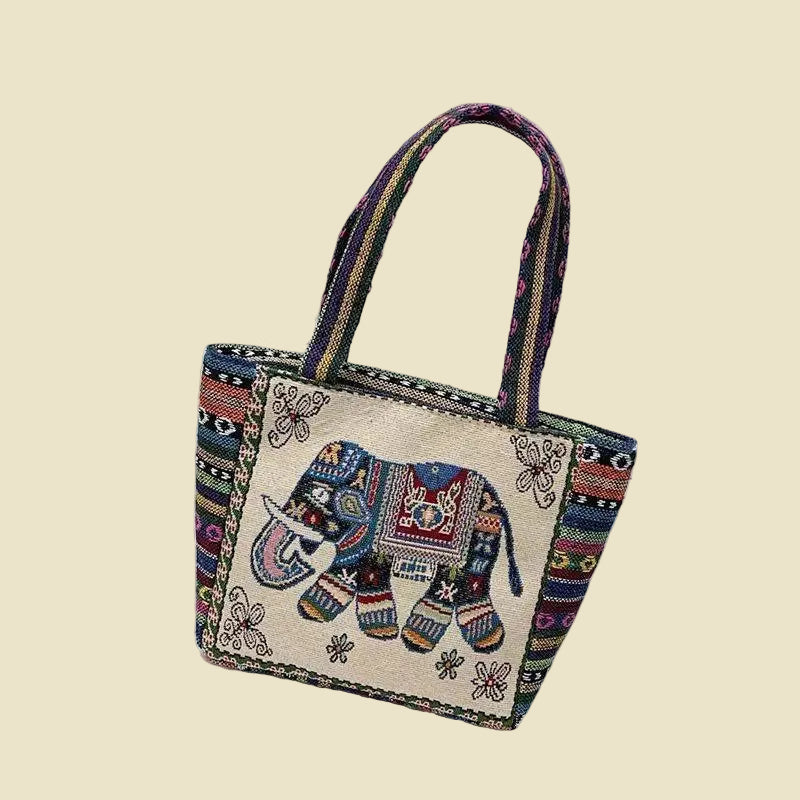 Woven canvas tote bag with colorful Thai elephant embroidery, featuring a zipper and boho-inspired design.