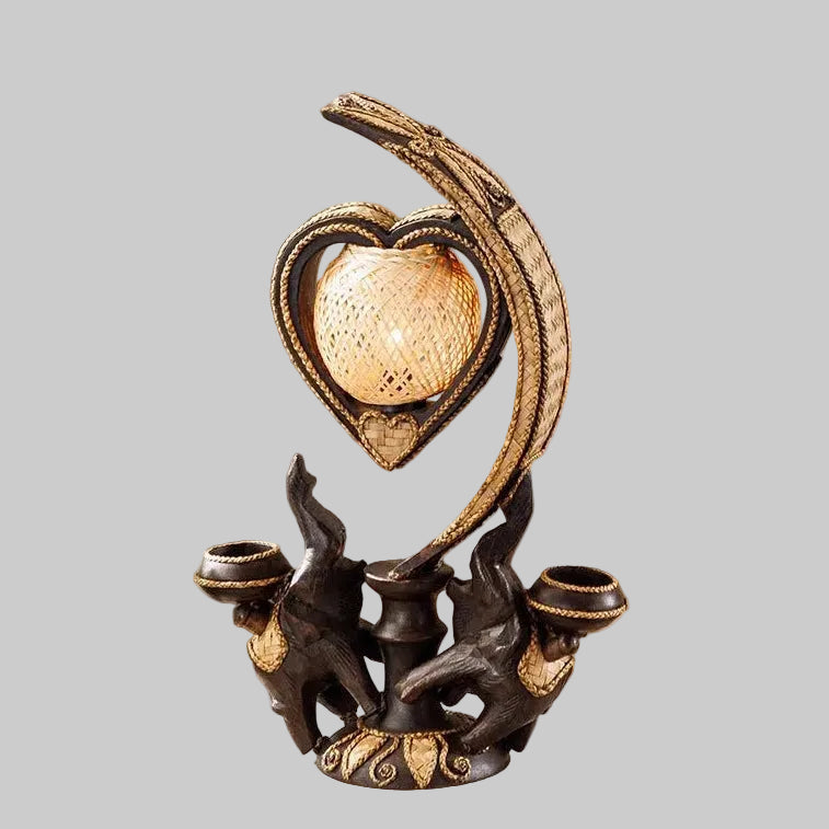 Handcrafted wooden elephant table lamp with a woven bamboo shade lighting up a rustic living space.