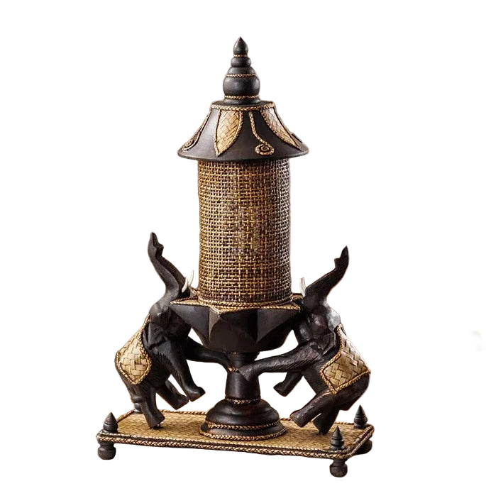 Handcrafted wooden elephant table lamp with a woven bamboo shade lighting up a rustic living space.
