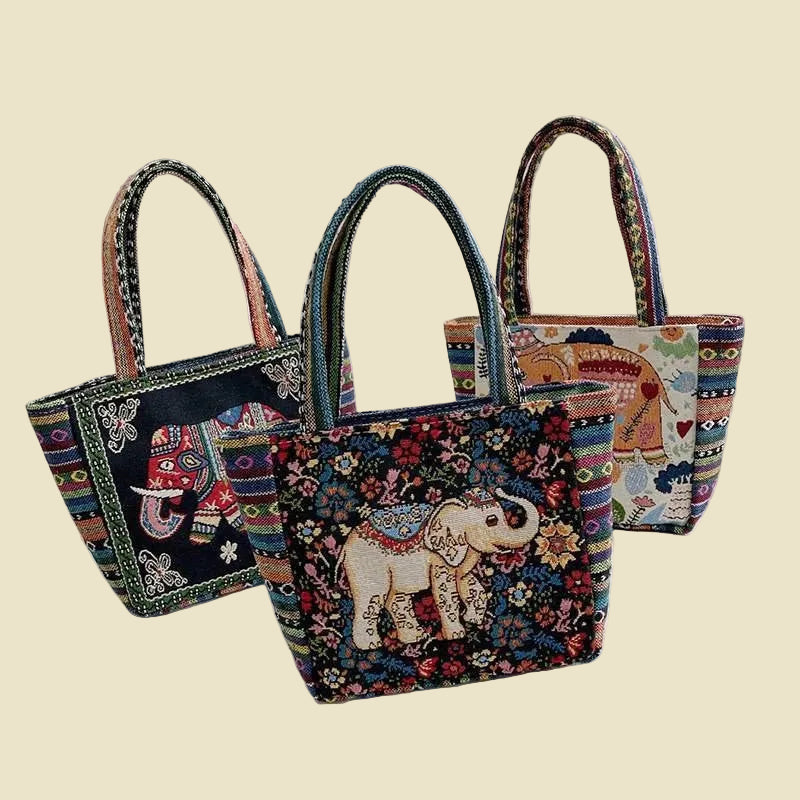 Woven canvas tote bag with colorful Thai elephant embroidery, featuring a zipper and boho-inspired design.