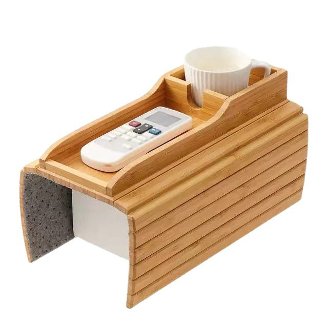 Bamboo sofa tray table with a cup holder and phone slot resting on a couch armrest.