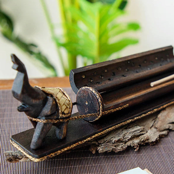 wooden elephant enclosed incense burner with smoke rising from 18 holes