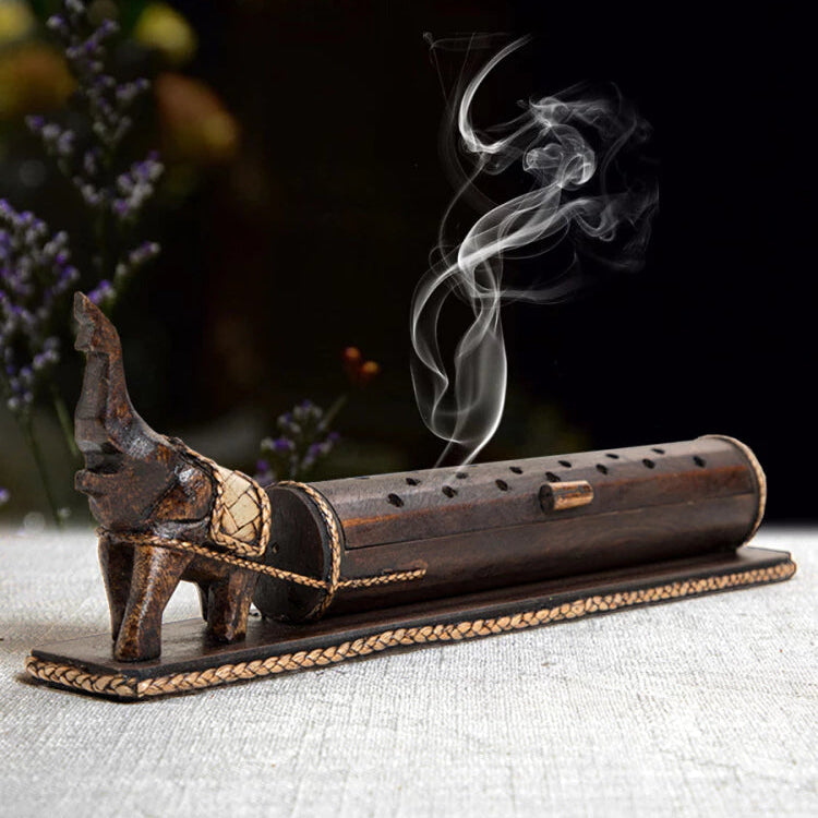 wooden elephant enclosed incense burner with smoke rising from 18 holes
