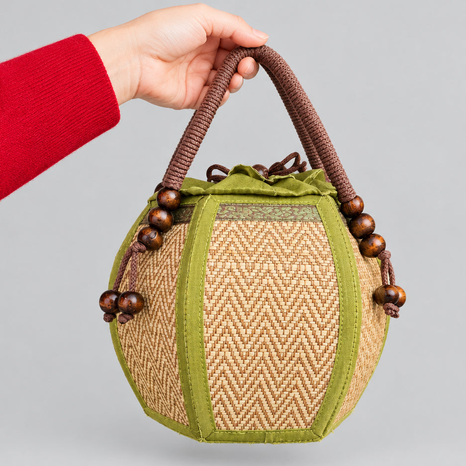 Woman carrying a 6-inch pumpkin-shaped straw woven bag on her wrist.