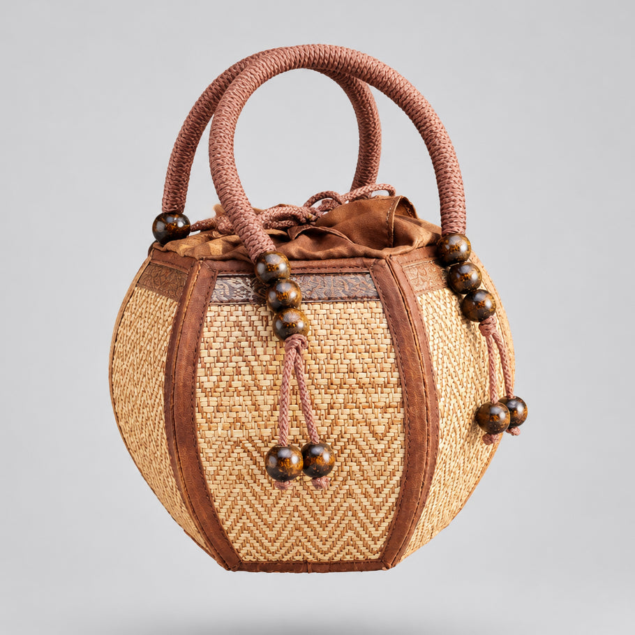 Woman carrying a 6-inch pumpkin-shaped straw woven bag on her wrist.